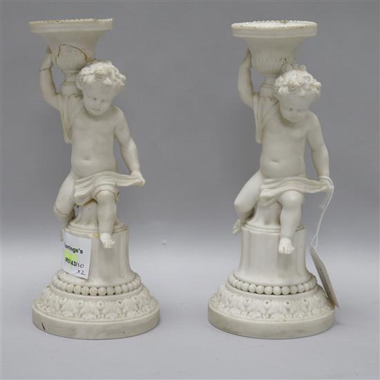 A pair of Victorian Minton bisque porcelain putti candlesticks H.24cm.